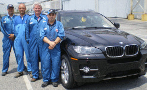 PPG employees, from left, Kevin Lowell (site manager), Michael Kleinz (IPP product specialist), Scott Hughes (application specialist) and Chris Mull (technical service representative), with a vehicle painted using PPG&rsquo;s new B1:B2 waterborne paint technology at the BMW plant in Spartanburg.
